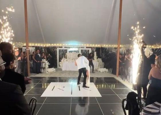 Couple's first dance under cold spark fountains inside a white wedding tent