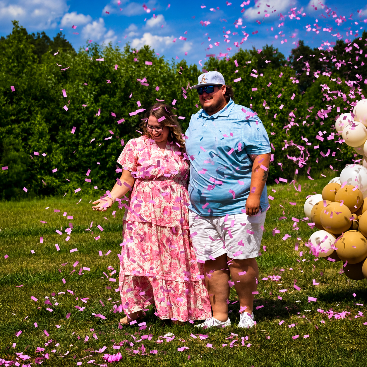 A couple's reaction during a pink confetti gender reveal
