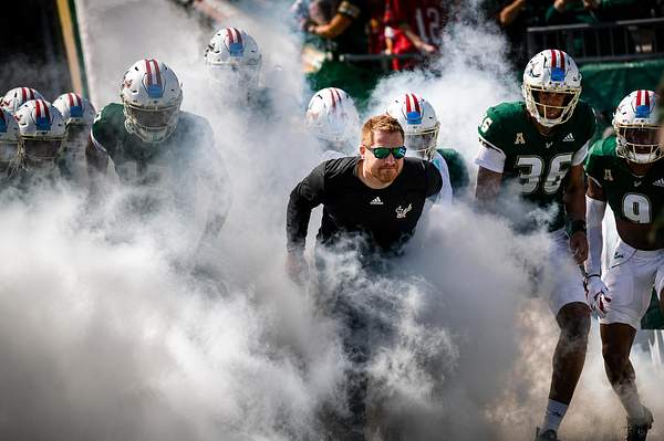 Football team emerging through dense CO₂ smoke during a tunnel entrance