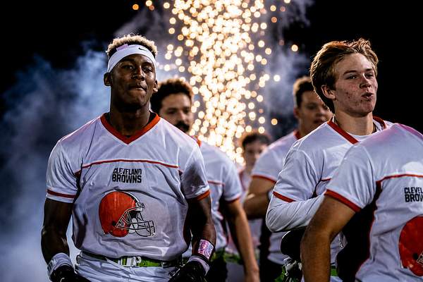 Athletes walking through cold spark pyrotechnics at night