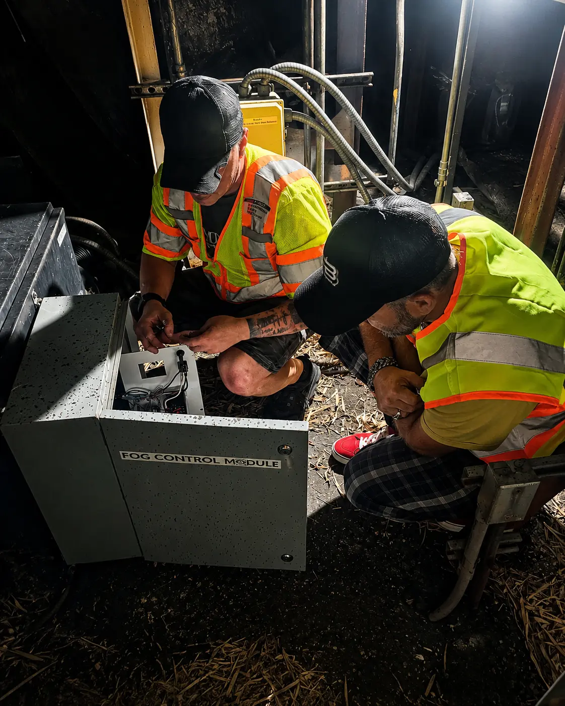 Imperial Pyro crew inspecting the fog control module during on-site commissioning