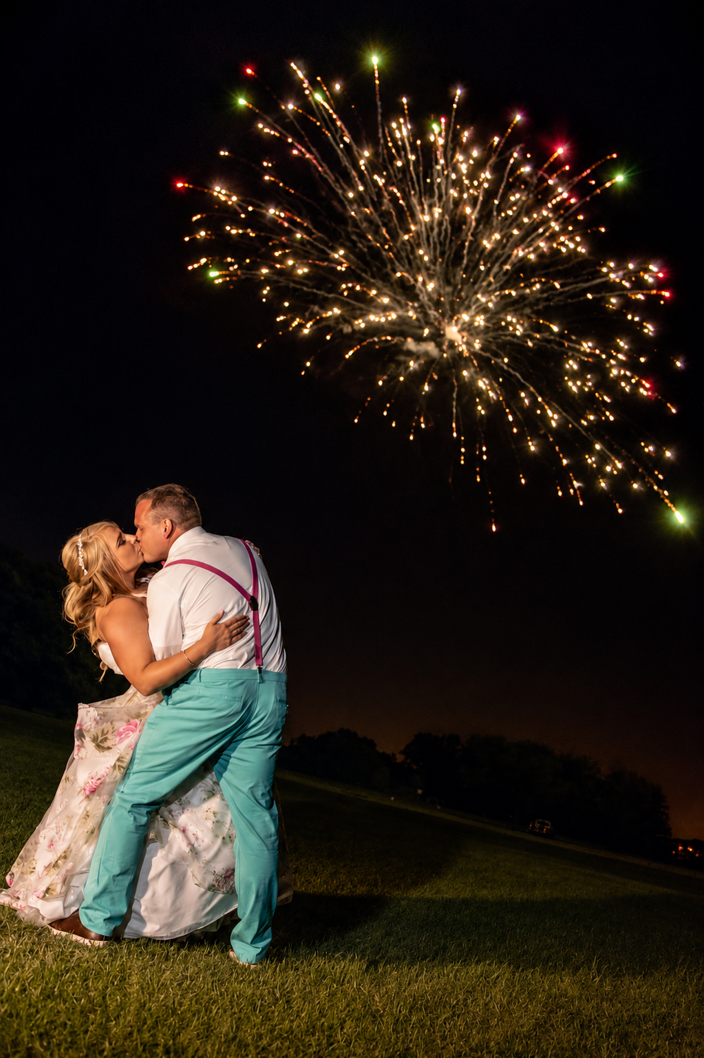 A wedding kiss under fireworks at Ever After Estate